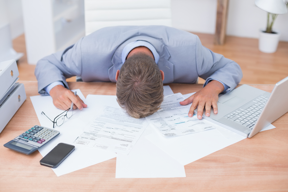 Man with head on table frustrated