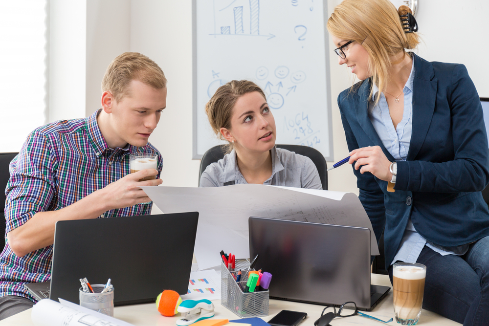 team members working together around a plan in the office